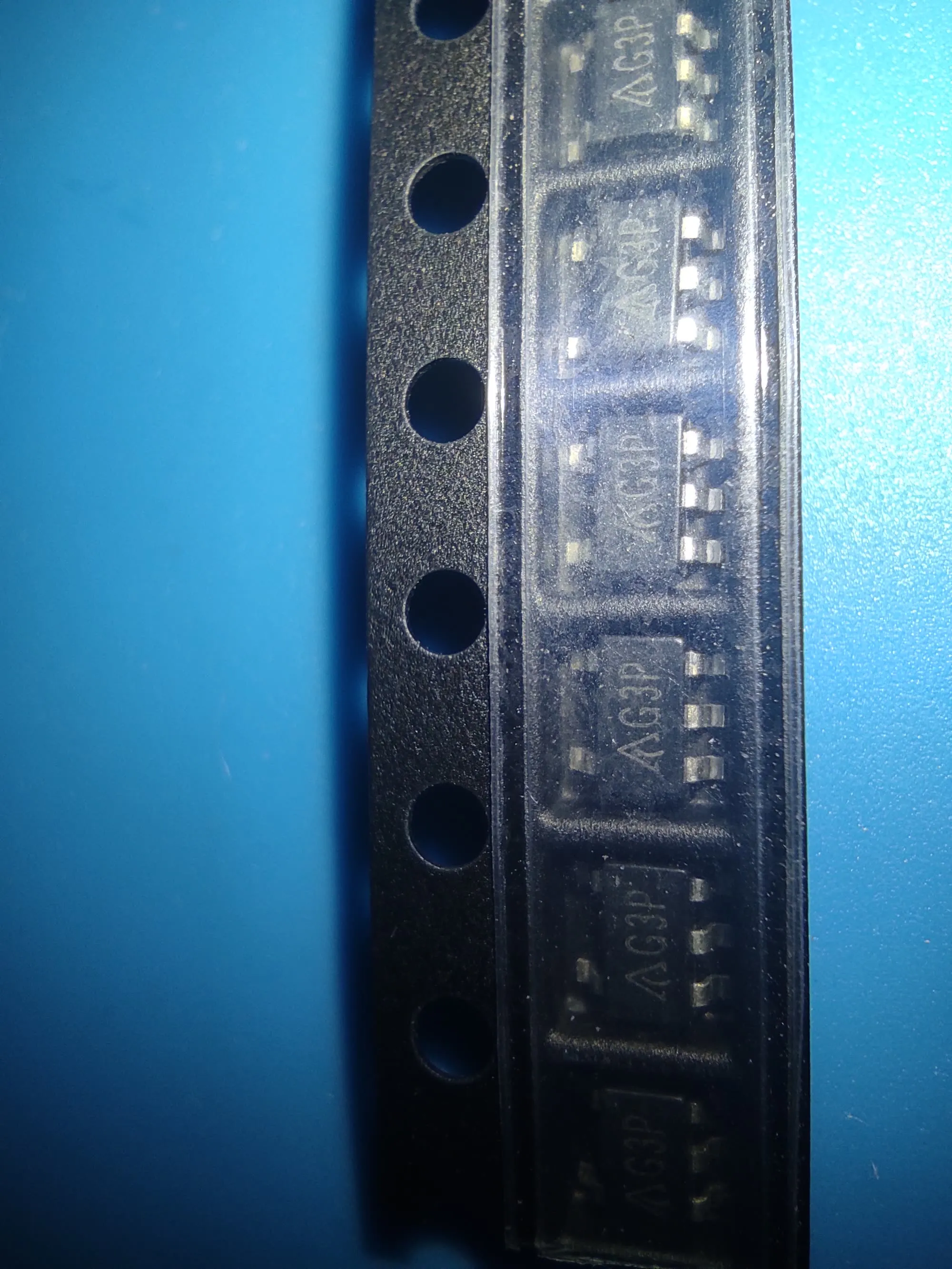 five SOT-23 chips marked G3P on a strip of carrier tape