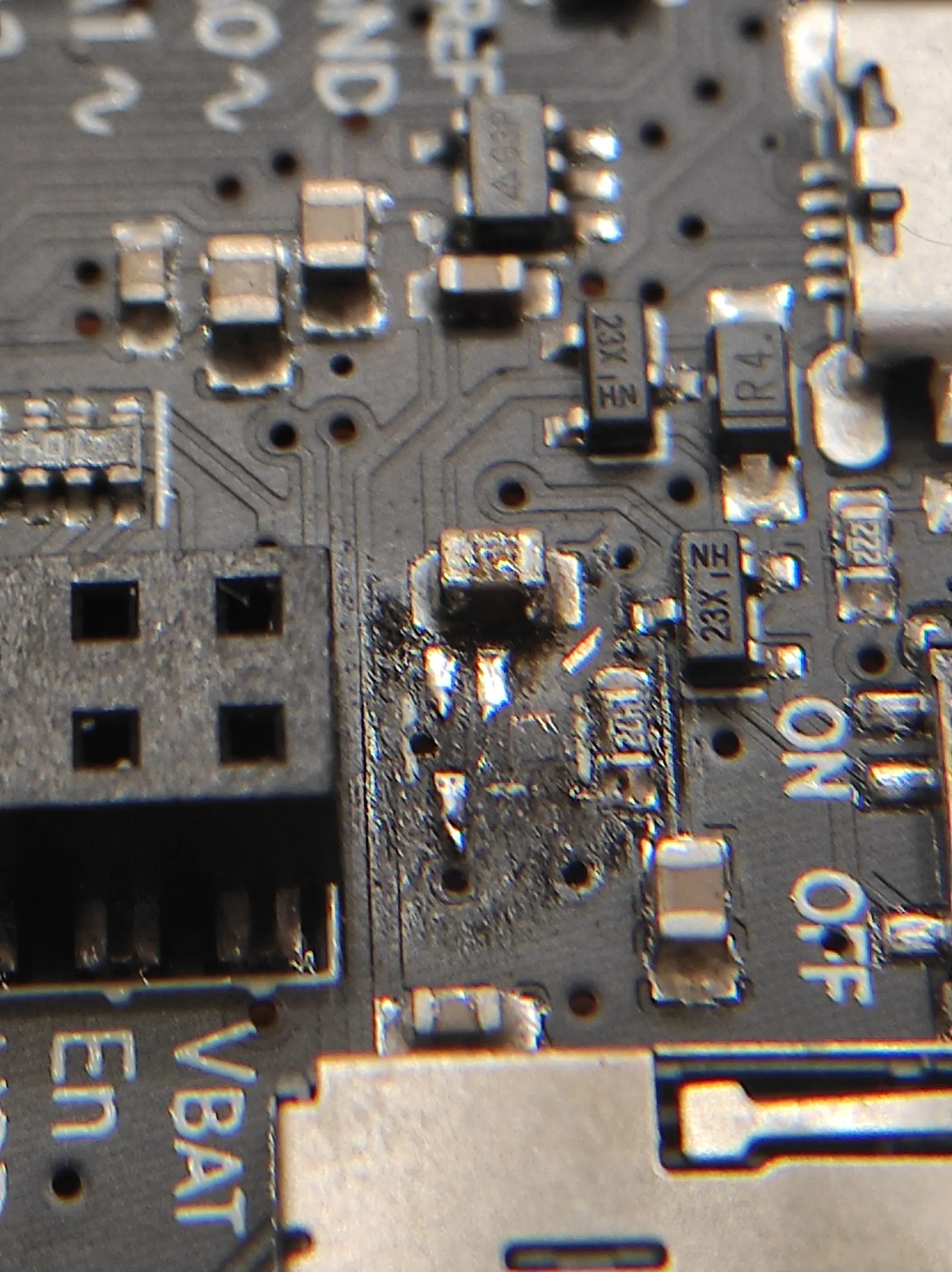 close-up of the PyGamer board with empty, charred solder pads beside the ON/OFF label